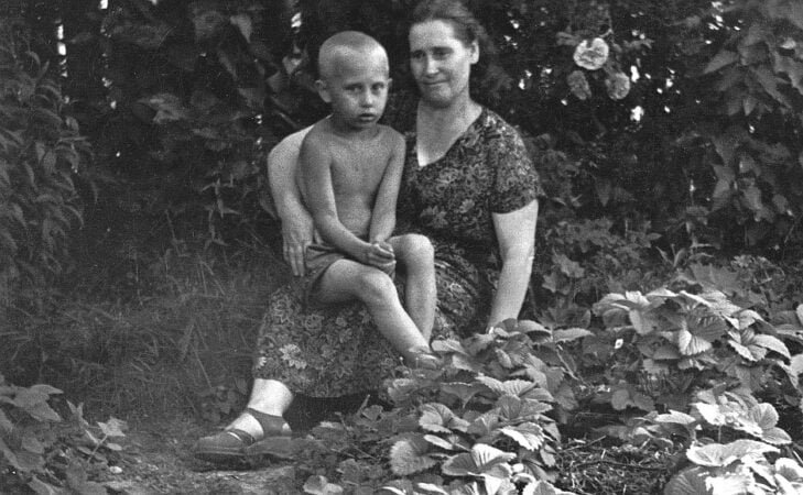 Maria Iwanowna Putina z synem na kolanach koło pola truskawek